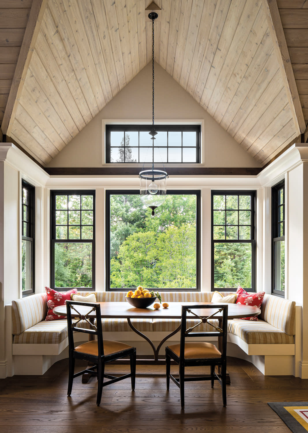A breakfast nook featuring a wooden table surrounded by four chairs, with soft lighting creating a warm atmosphere.