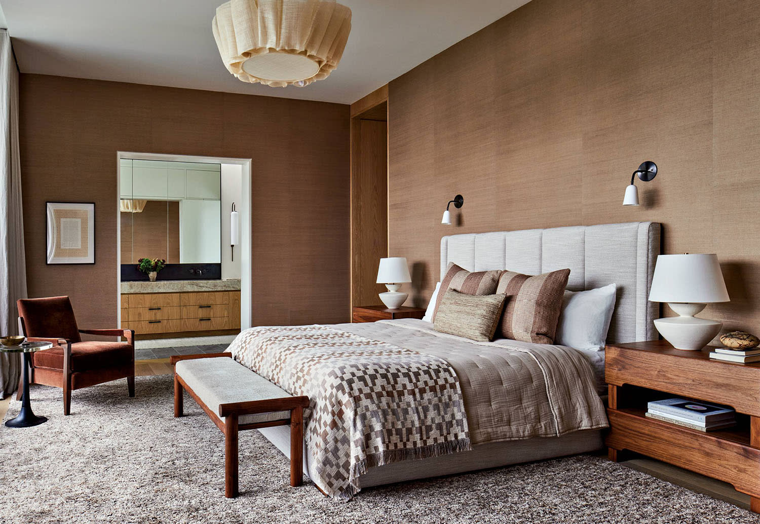 brown grass cloth covers the walls around a primary bedroom with walnut furnishings