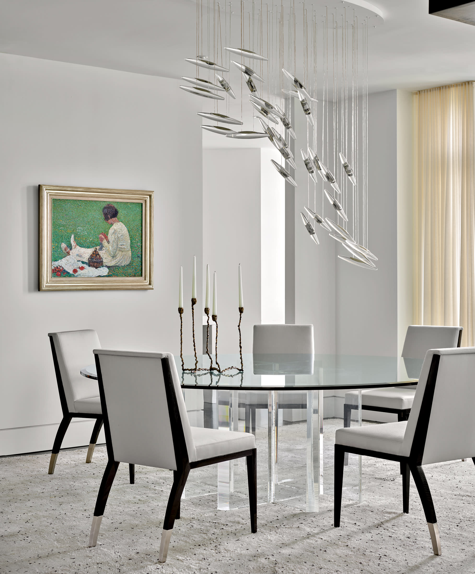 bright white dining room with a sculptural chandelier and a Post Impressionist painting on the wall