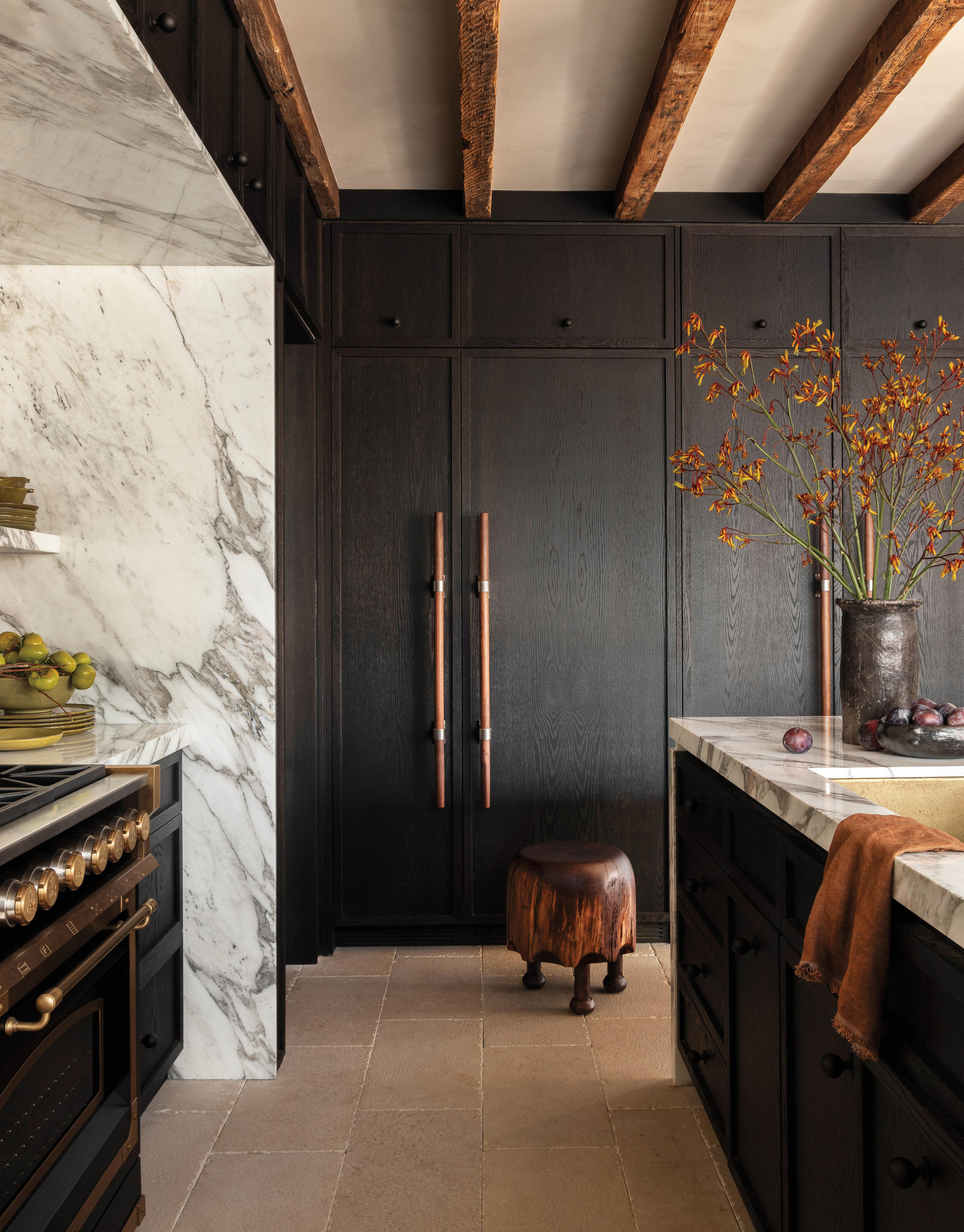 black cabinetry in an elegant kitchen with walnut finishes and exposed beams