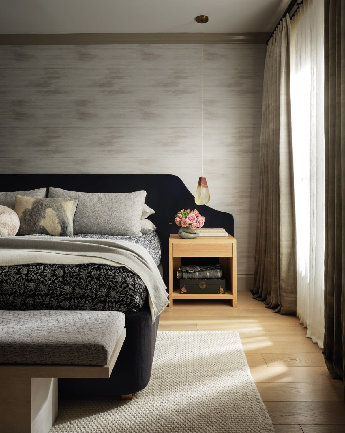 modern bedroom with a wallcovering in a grayish-tan tone and a black upholstered bed