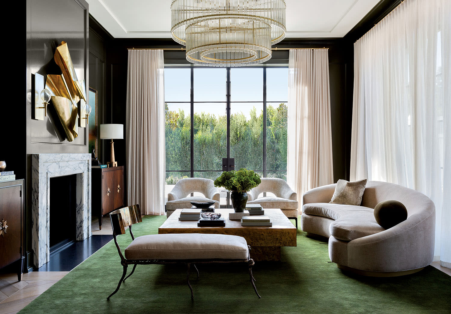 transitional living room with a green rug and a tiered chandelier