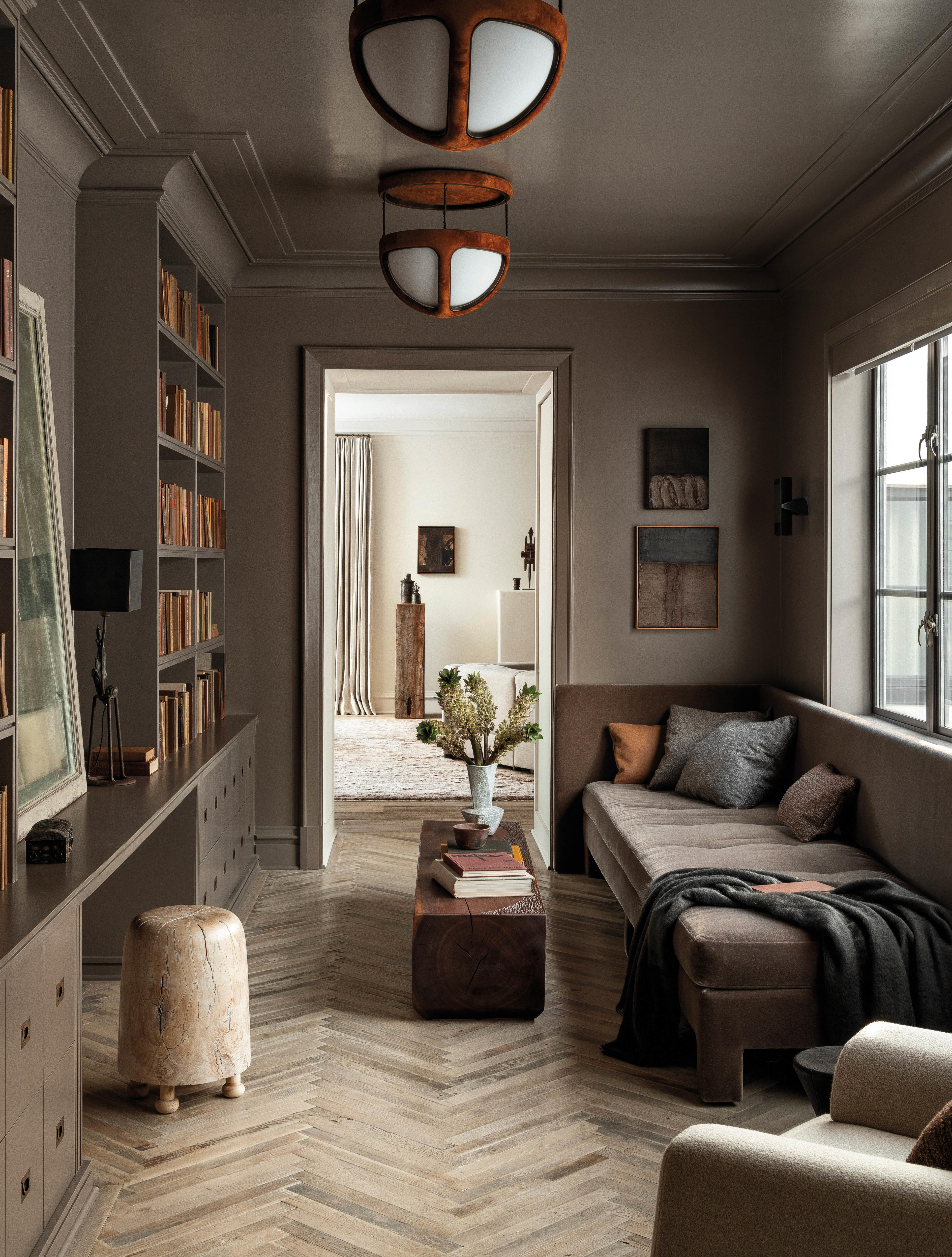 library room in a light brown tone with a sofa and rustic fixtures