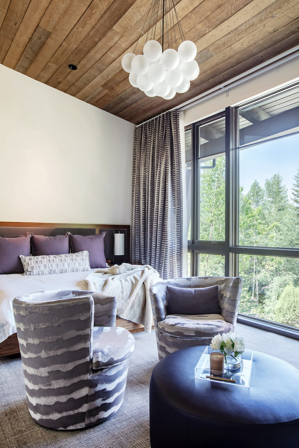 Primary bedroom with wood ceiling and playful lighting fixture