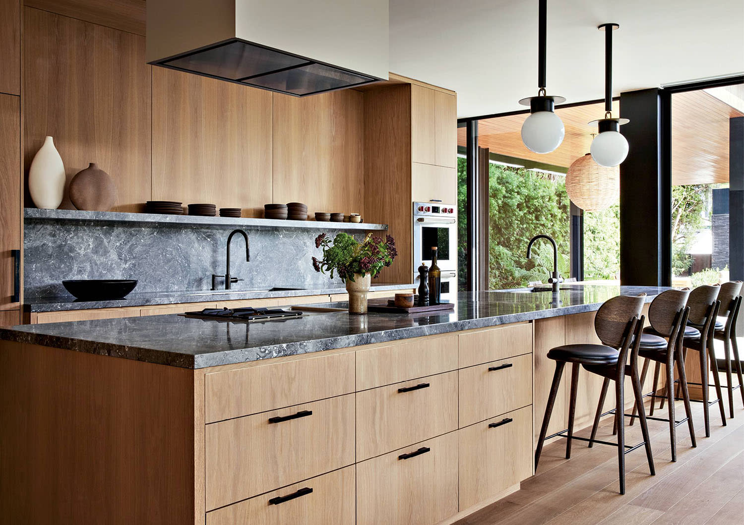 oak-clad kitchen with a black marble backsplash