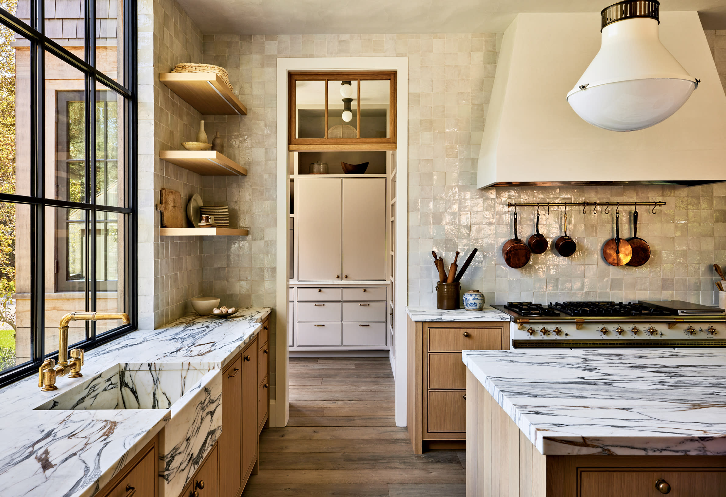 zellige tiles and stone counters interact in a classic kitchen in neutral tones