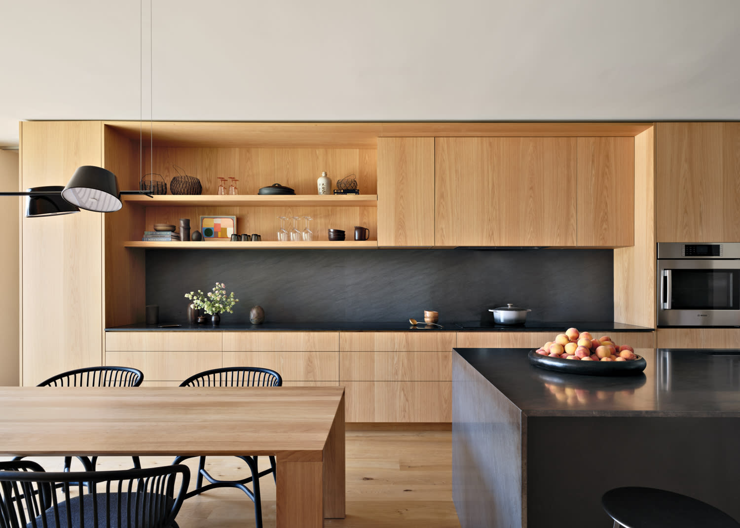 kitchen with oak cabinetry and black backsplash and matching island