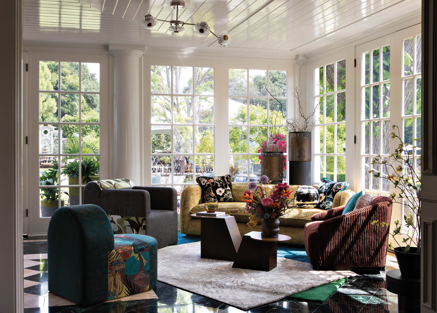 living room with multiple seating options in bright colors and geometric coffee tables