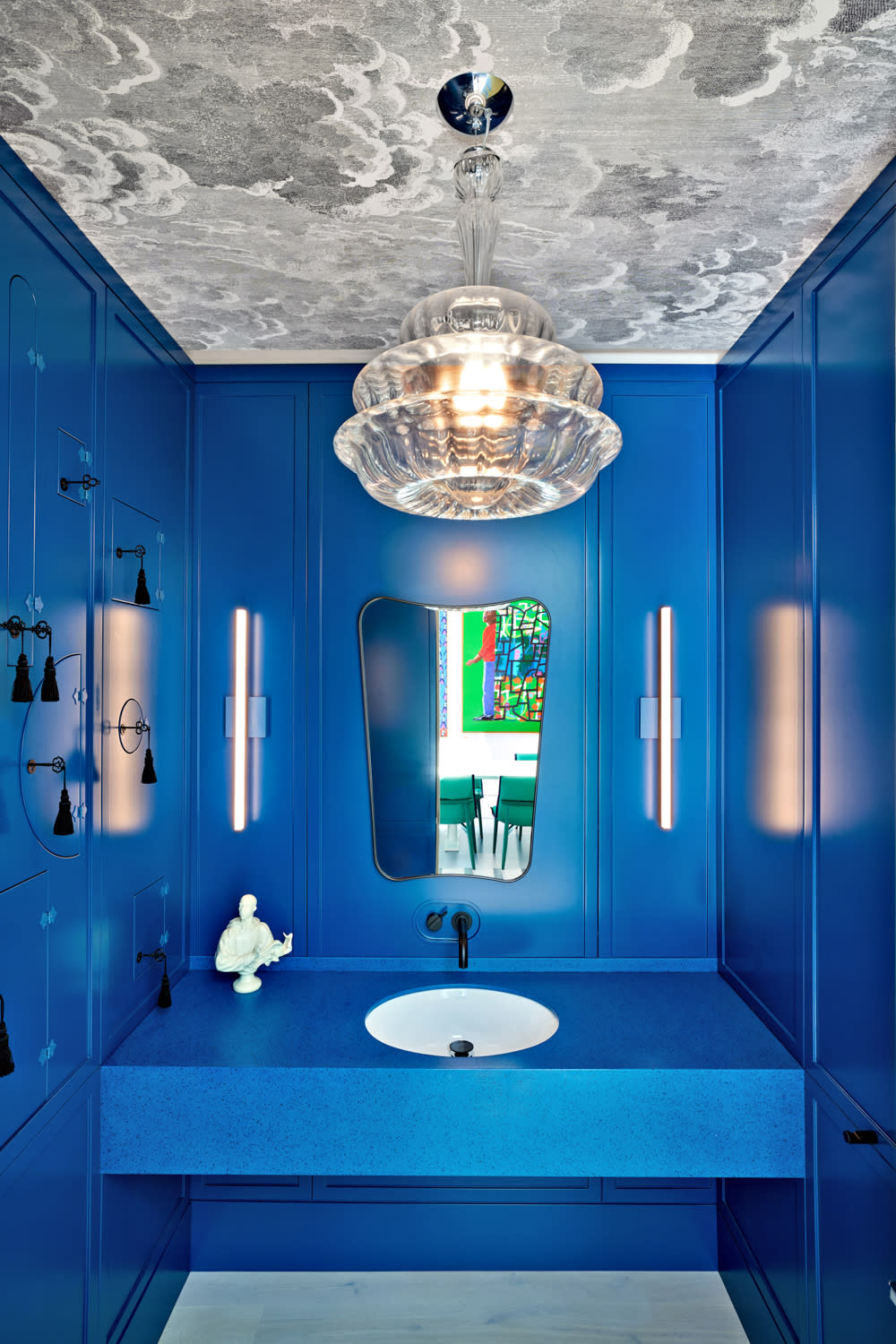 vibrant blue powder room with a crystal light fixture