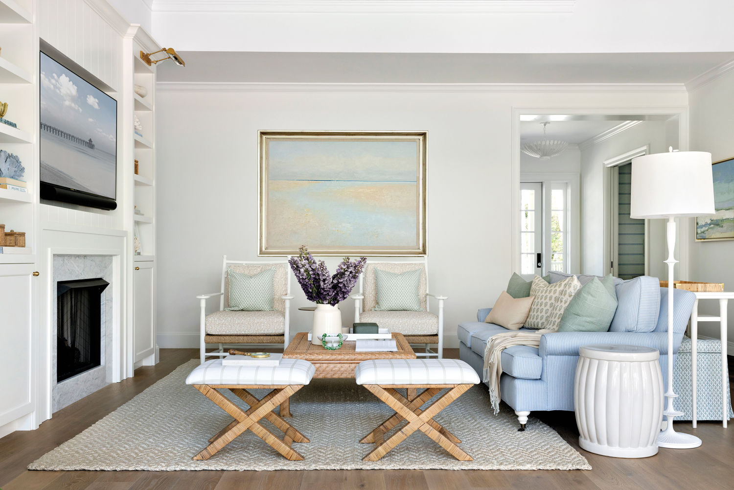 Great room by Bria Hammel with twin benches, wicker coffee table, blue sofa and light tones