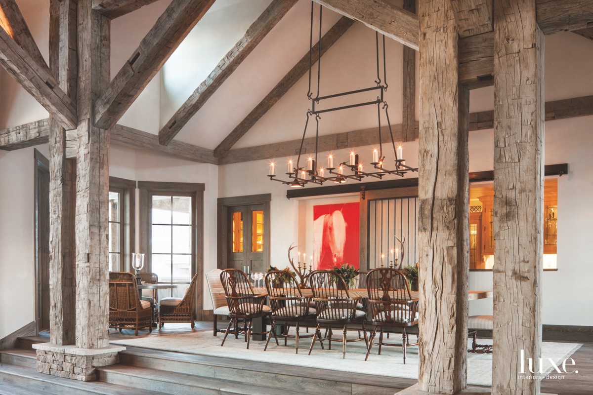 country dining room table framed by timbers antique chairs