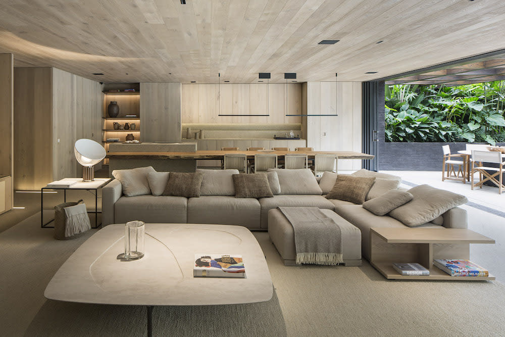 A contemporary living room featuring European oak floors and a spacious sectional couch, elegantly arranged for comfort and style.