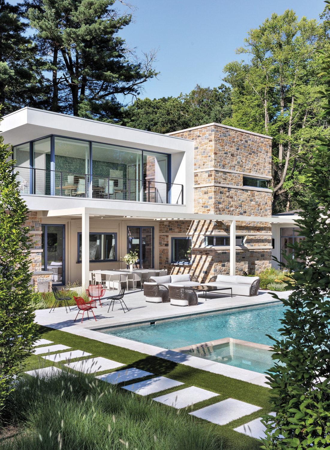 exterior of luxe pool house with lush foliage all around