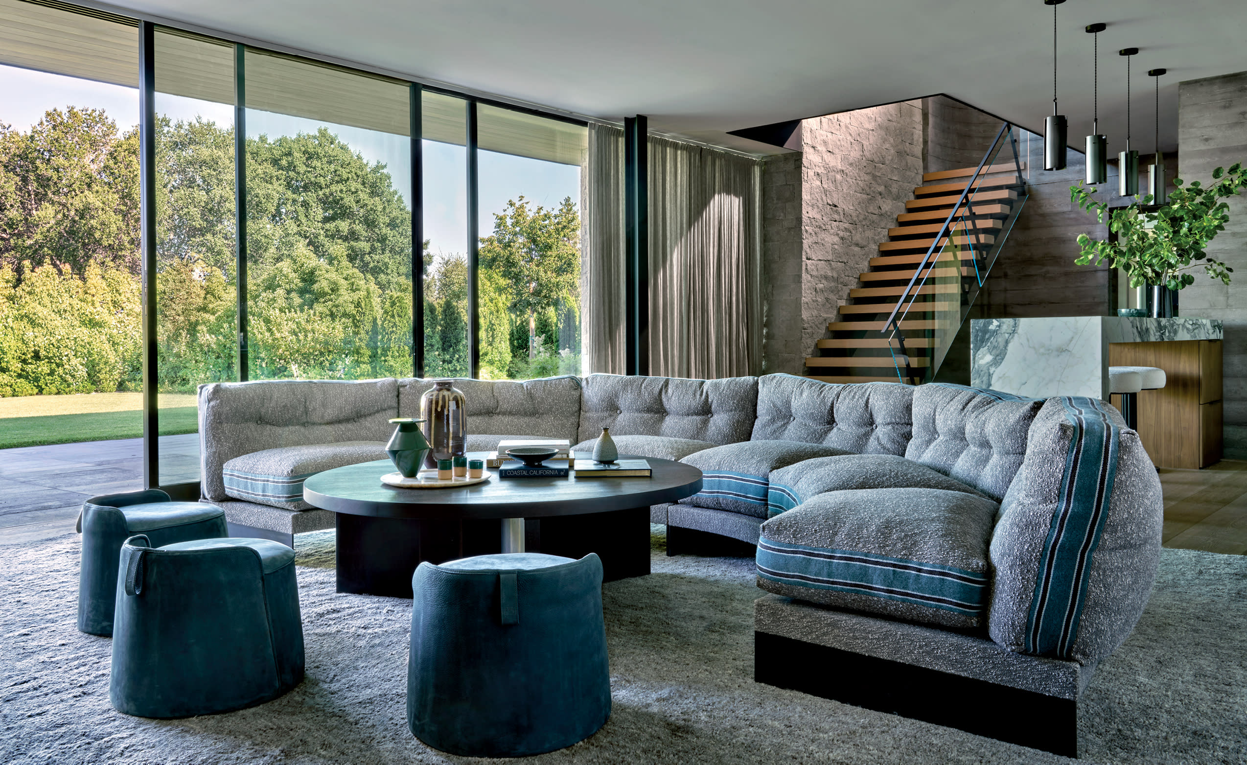 lounge with curvy blue-striped sofa and blue stools with accent rug