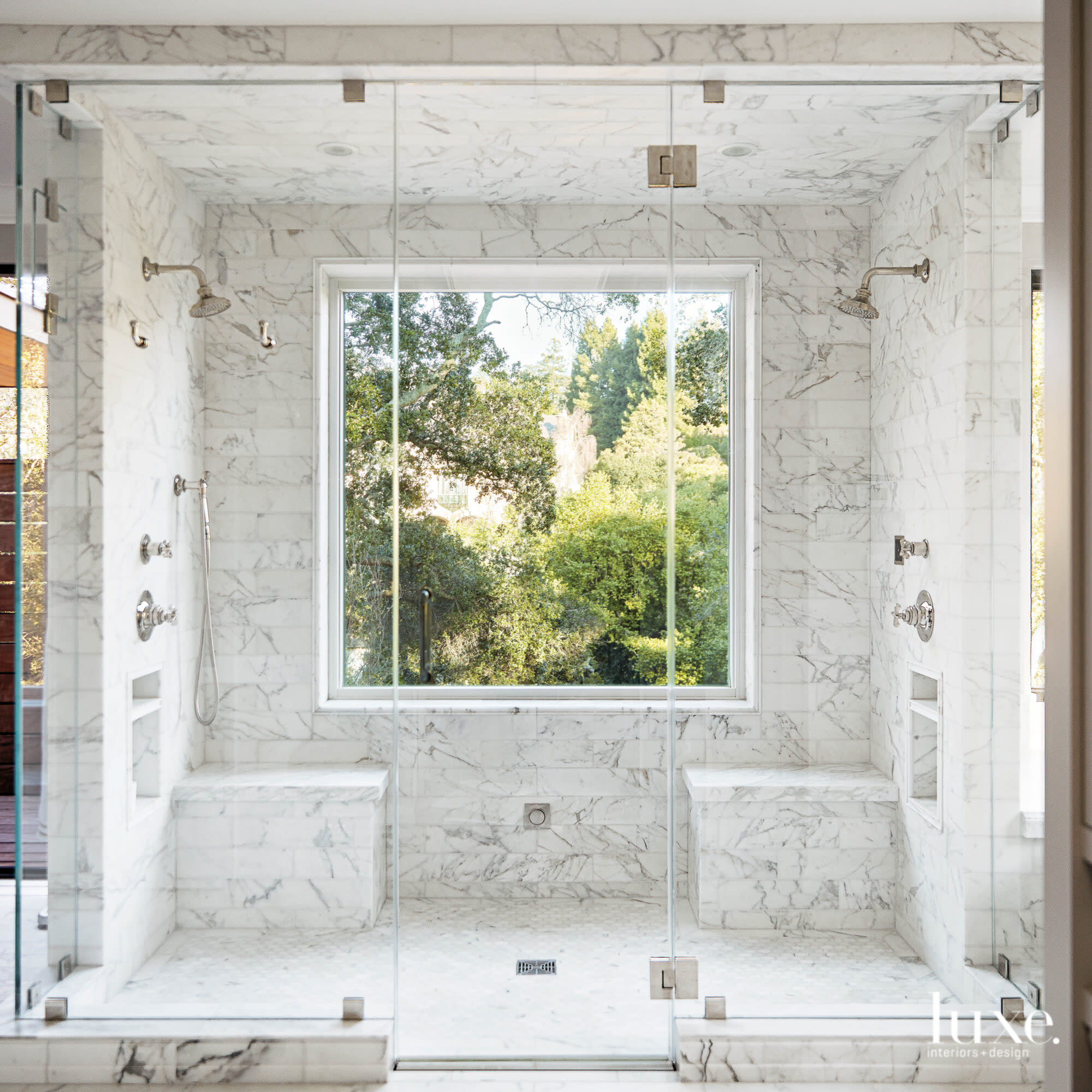 The primary bathroom has a shower with a leafy view.