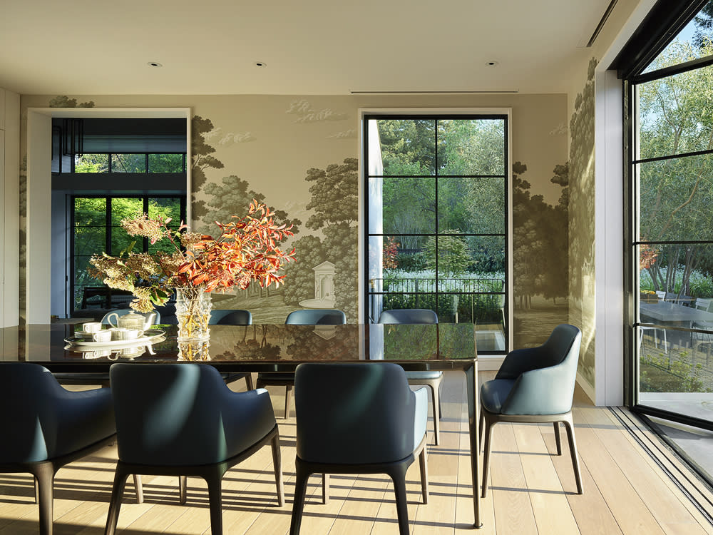 A spacious dining room featuring European oak flooring, a large table and a prominent window allowing natural light to illuminate the space.