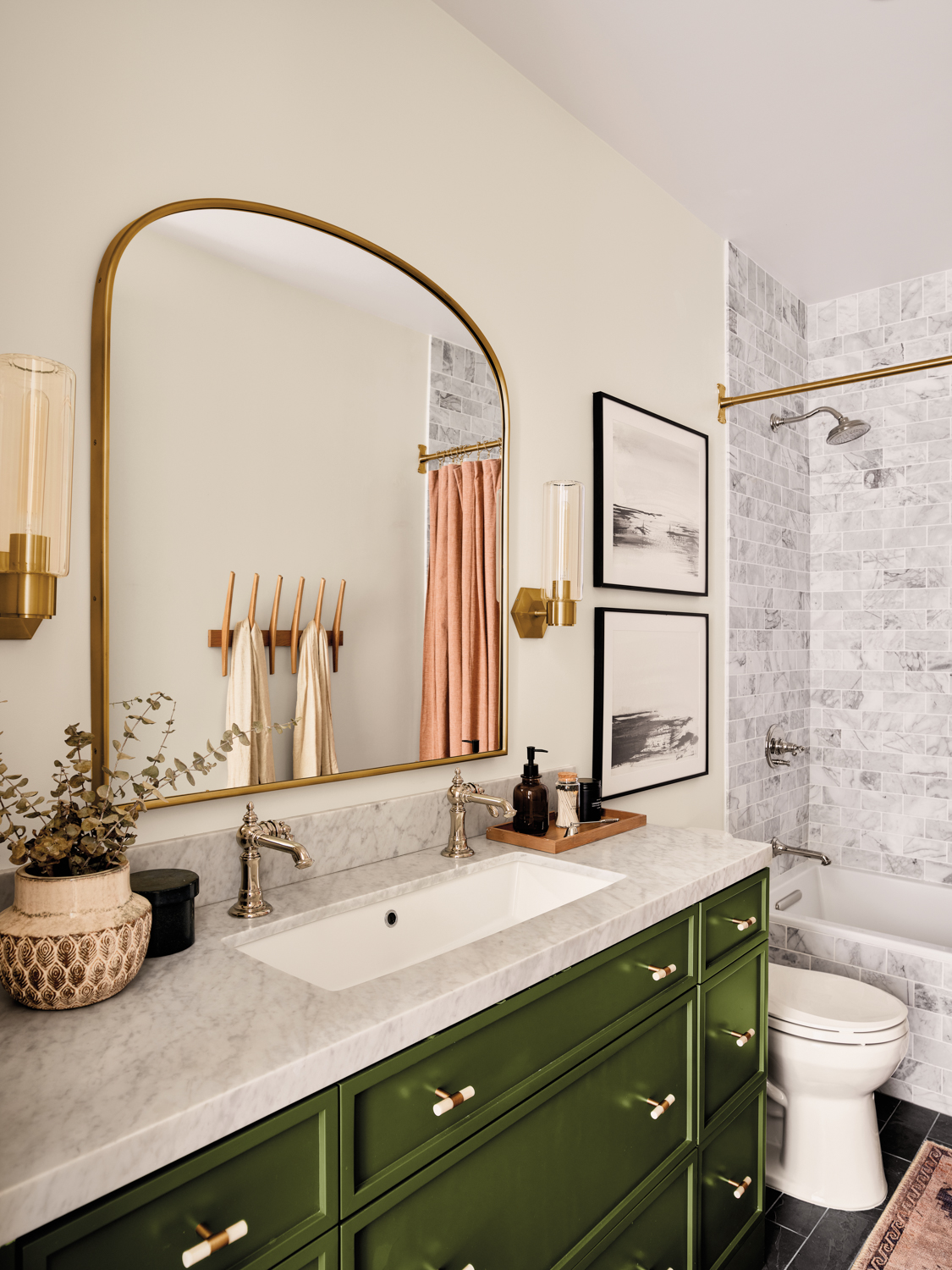 modern bathroom with green cabinetry topped with gray-and-white marble countertop