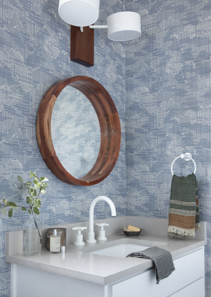 Blue wallpapered bathroom with white faucet