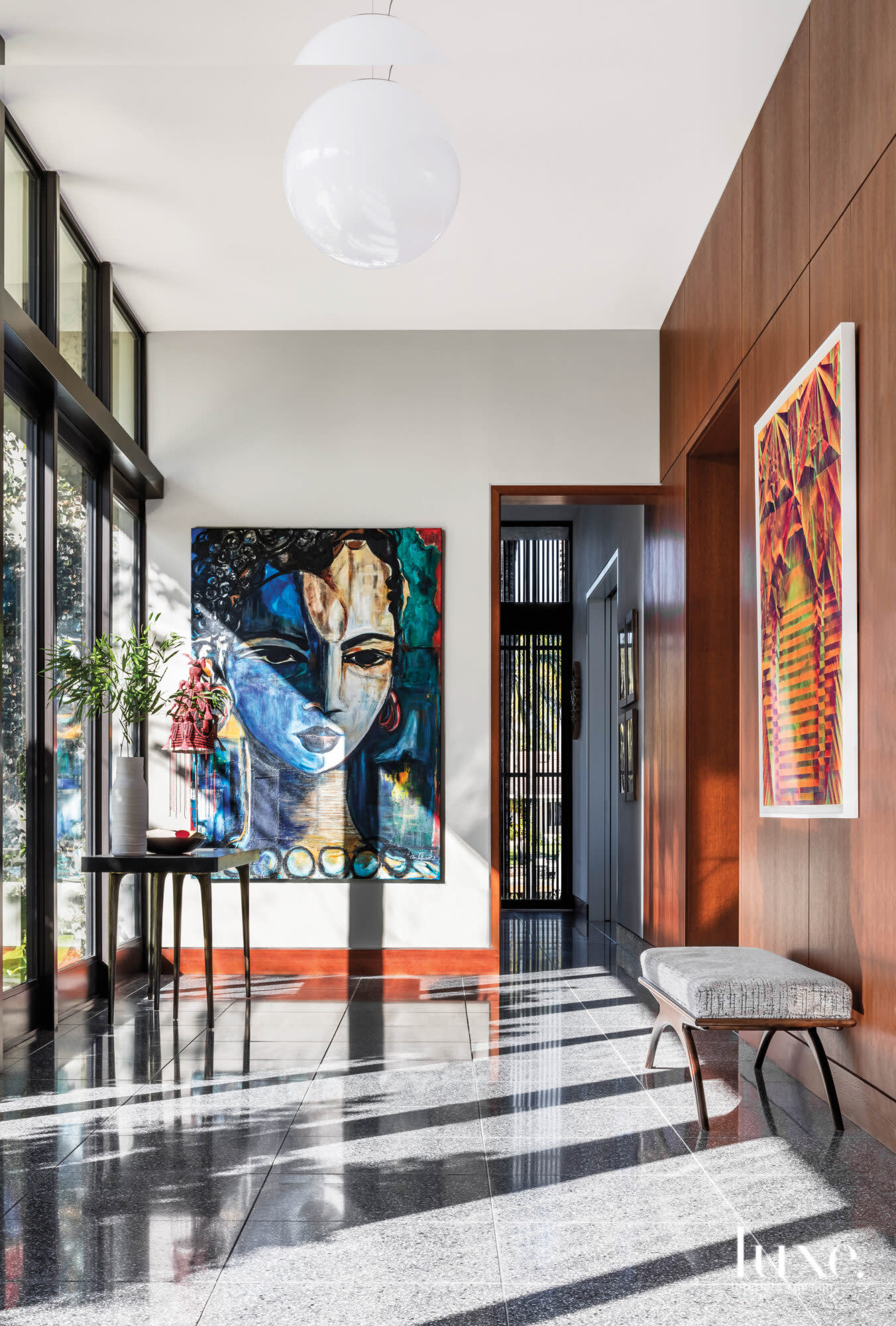 modern entry with vibrant artwork, glass and wood wall paneling