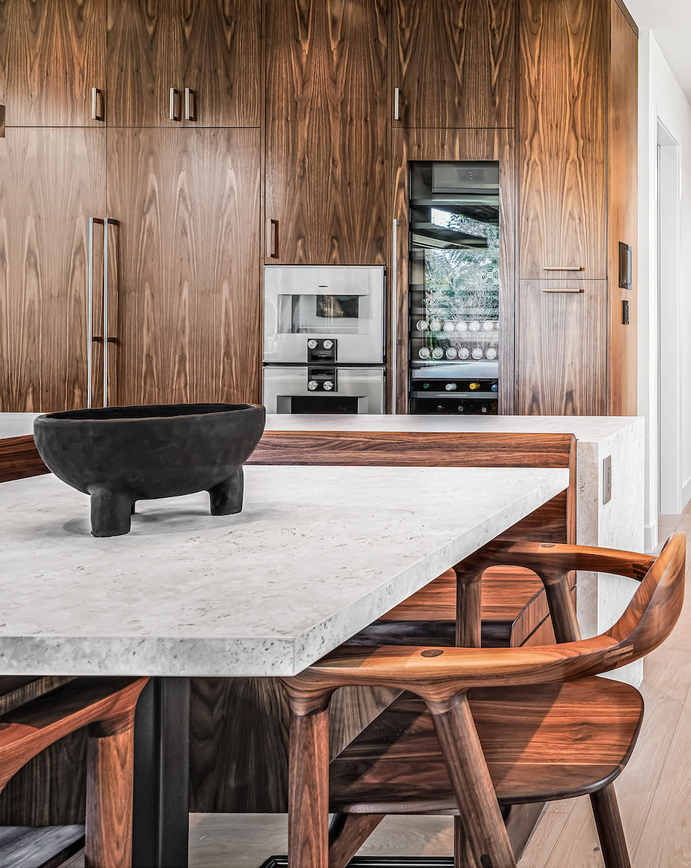 A cozy kitchen featuring a wooden table surrounded by chairs, creating an inviting dining space.