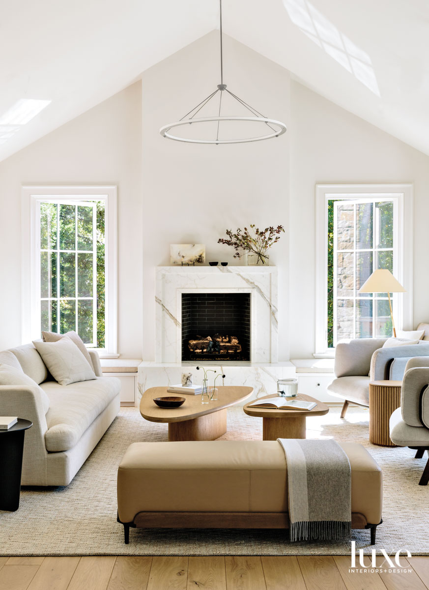 A living room is arranged around a fireplace.