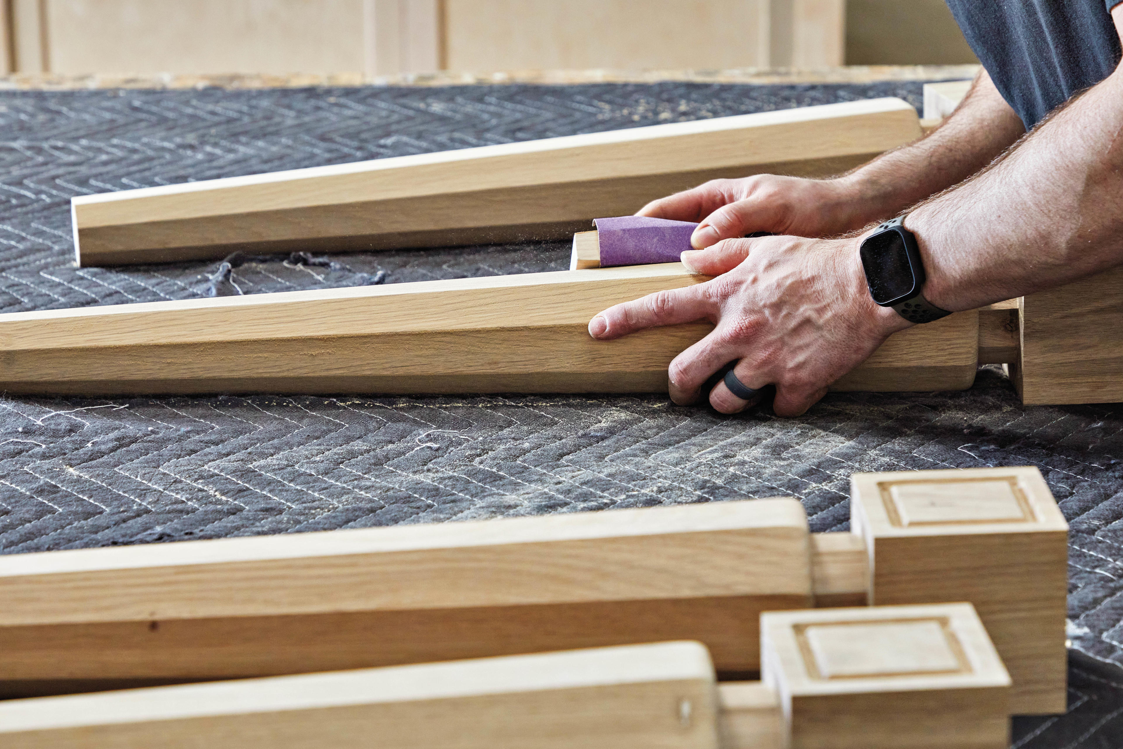 a person sands table legs