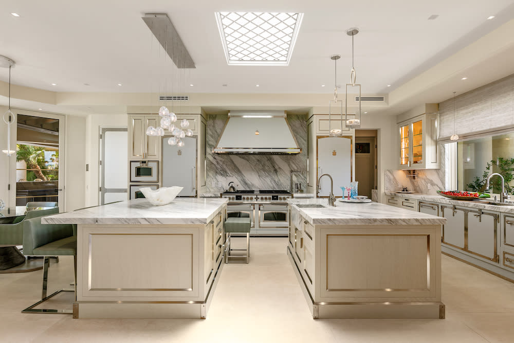 Modern white kitchen featuring two large islands and range.
