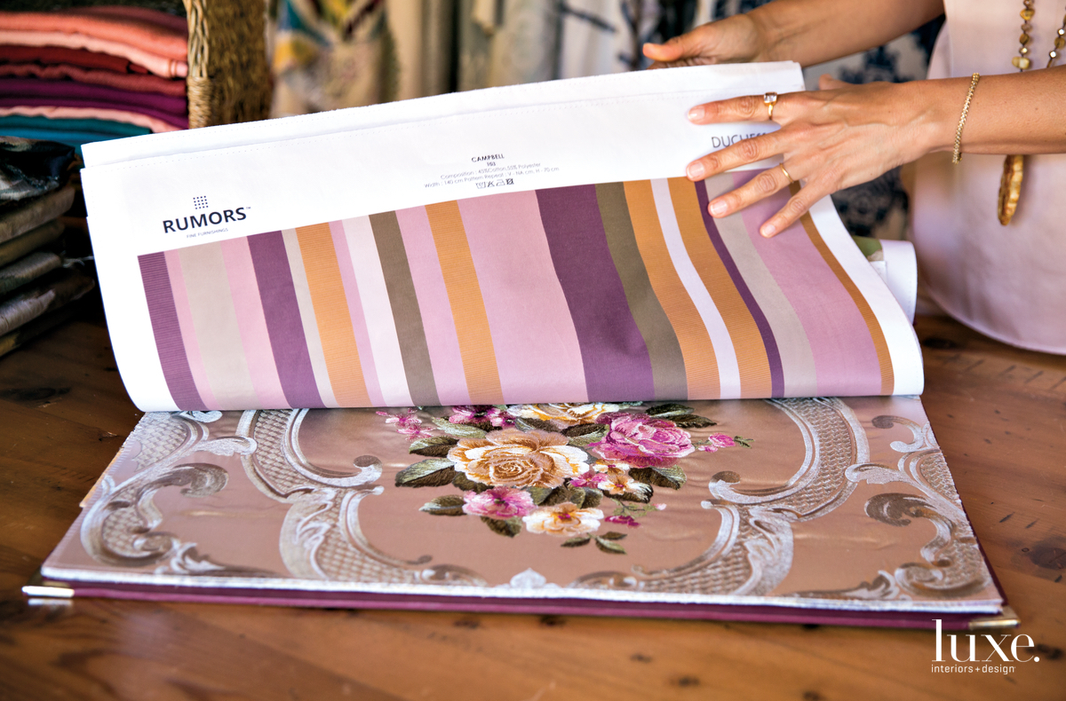 In her space, which also serves as a retail outlet, a chair is stacked high with colorful pillows.