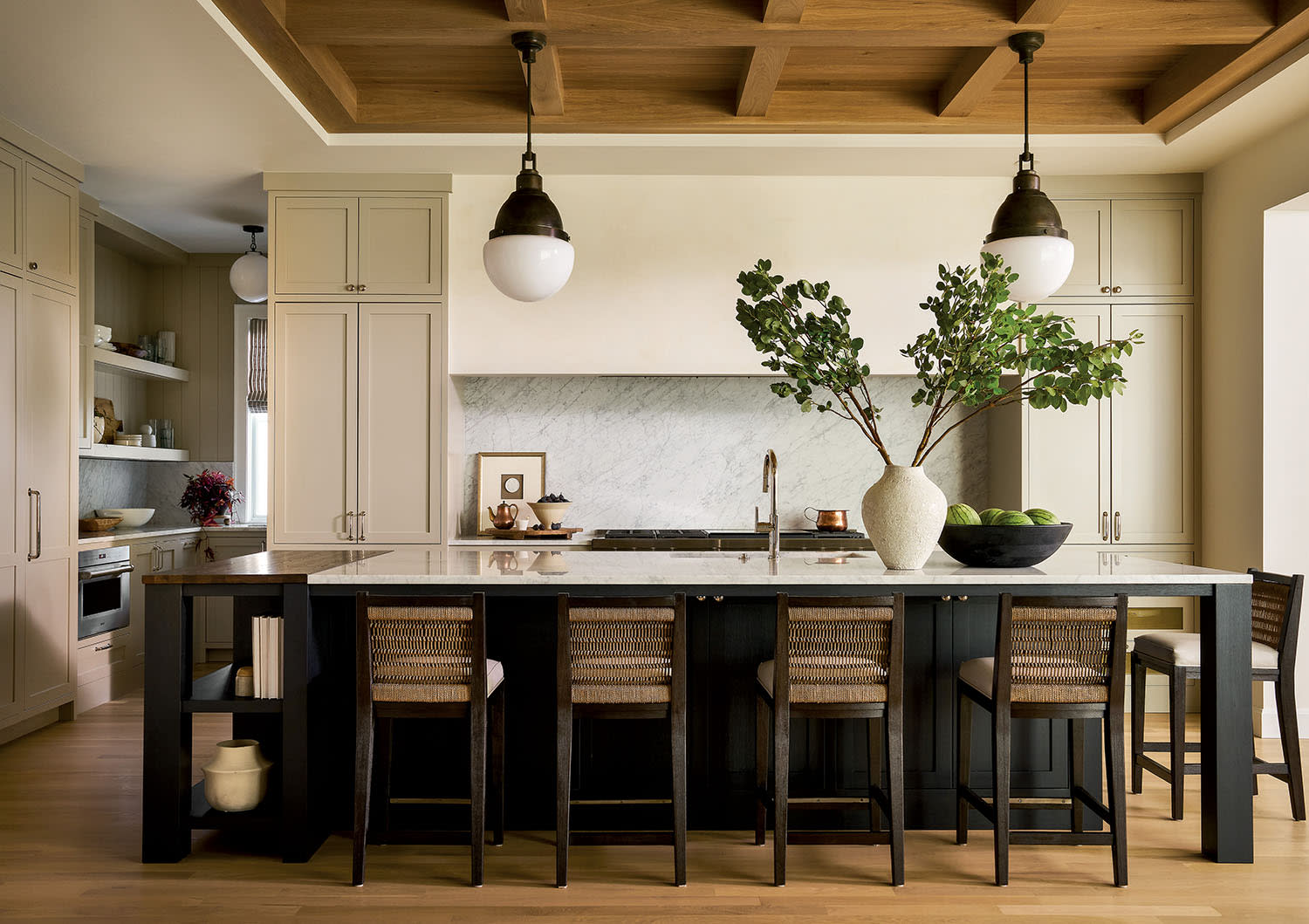 A spacious kitchen featuring wooden beams and a large central island, creating a warm and inviting atmosphere.