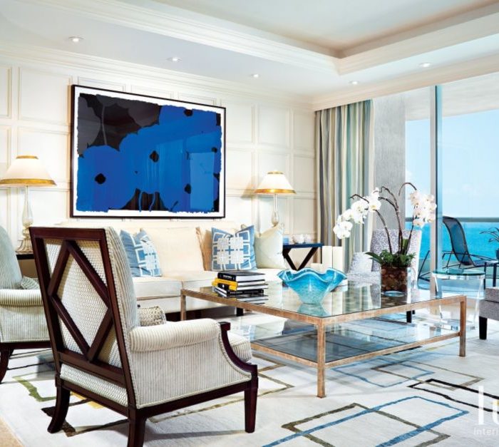 In the living room, two pairs of armchairs—one set pale blue, the other tan and cream—reference sea and sand, while a white sofa allows for Poppies—a bold blue contemporary framed silk screen by Donald Sultan—suspended behind it to make a stunning impact. A wall of windows permits light and the views of the ocean to flood in.