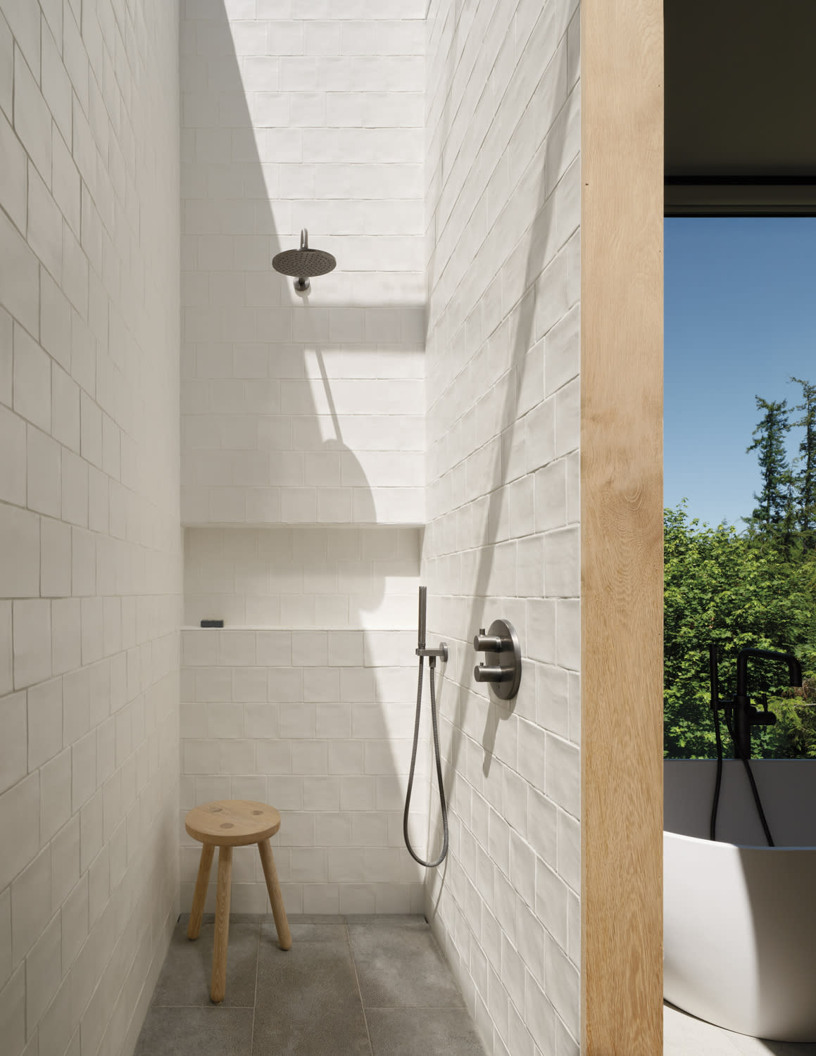 A modern bathroom featuring a shower underneath a skylight