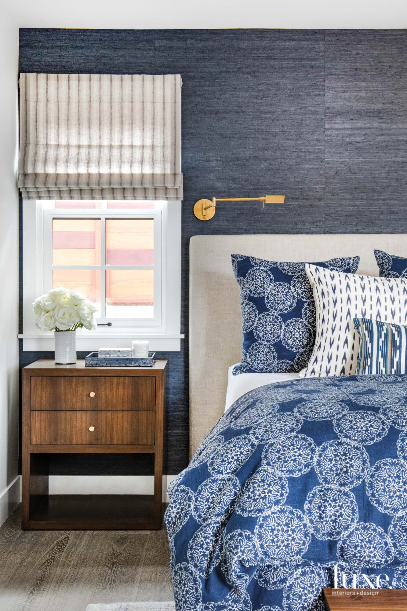 Bedroom shot with grasscloth covered walls and bed with blue print lines
