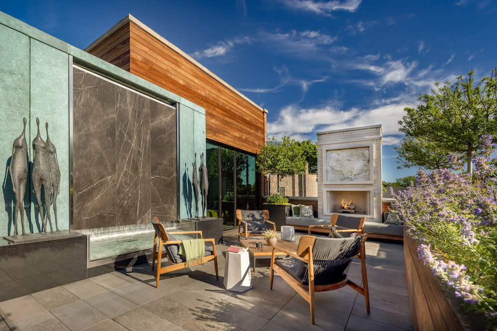 Rooftop room with decorative waterfall wall, sculptures and fireplace.