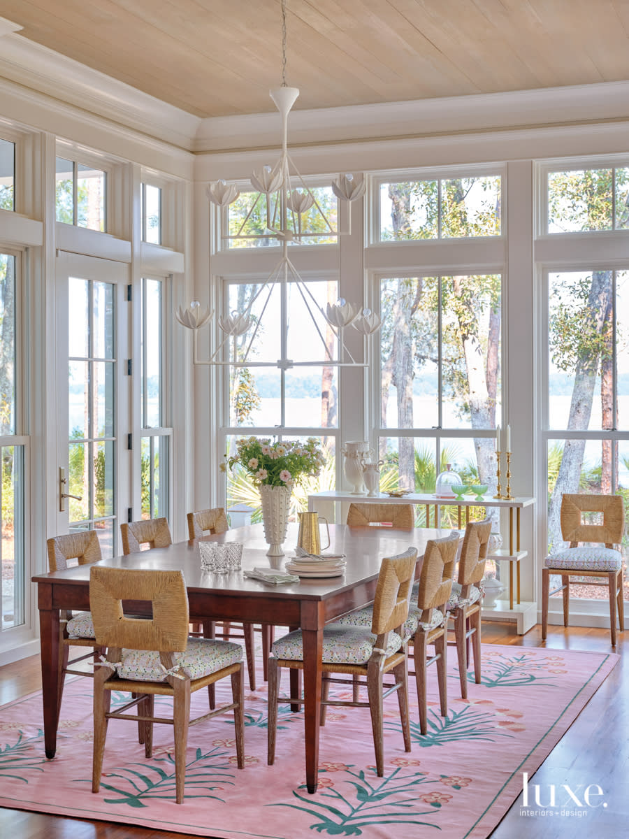 breakfast room with floor to cieling windows, pink rug and custom dining table