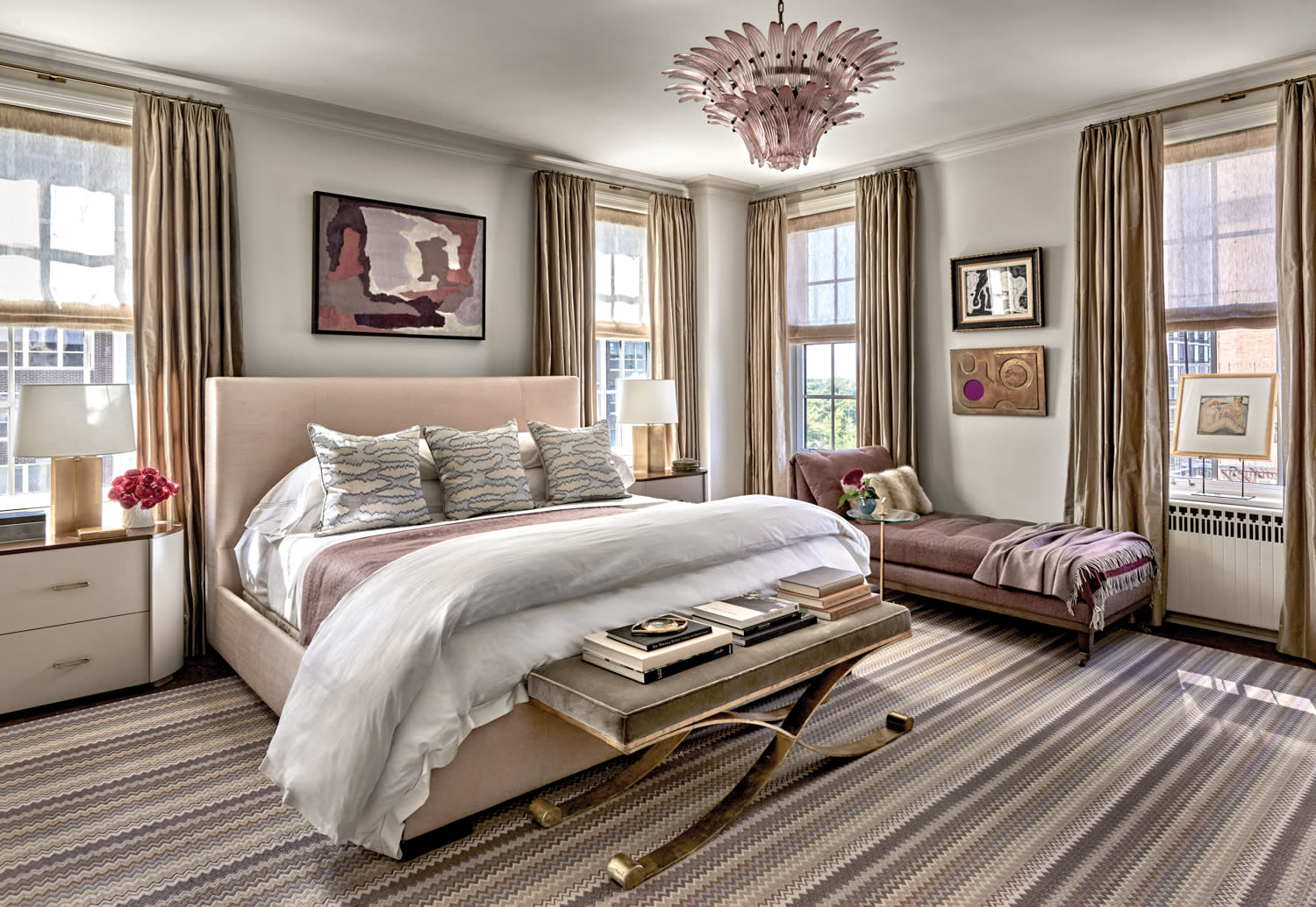 classic bedroom with a Murano-glass chandelier over the bed and a striped rug underneath
