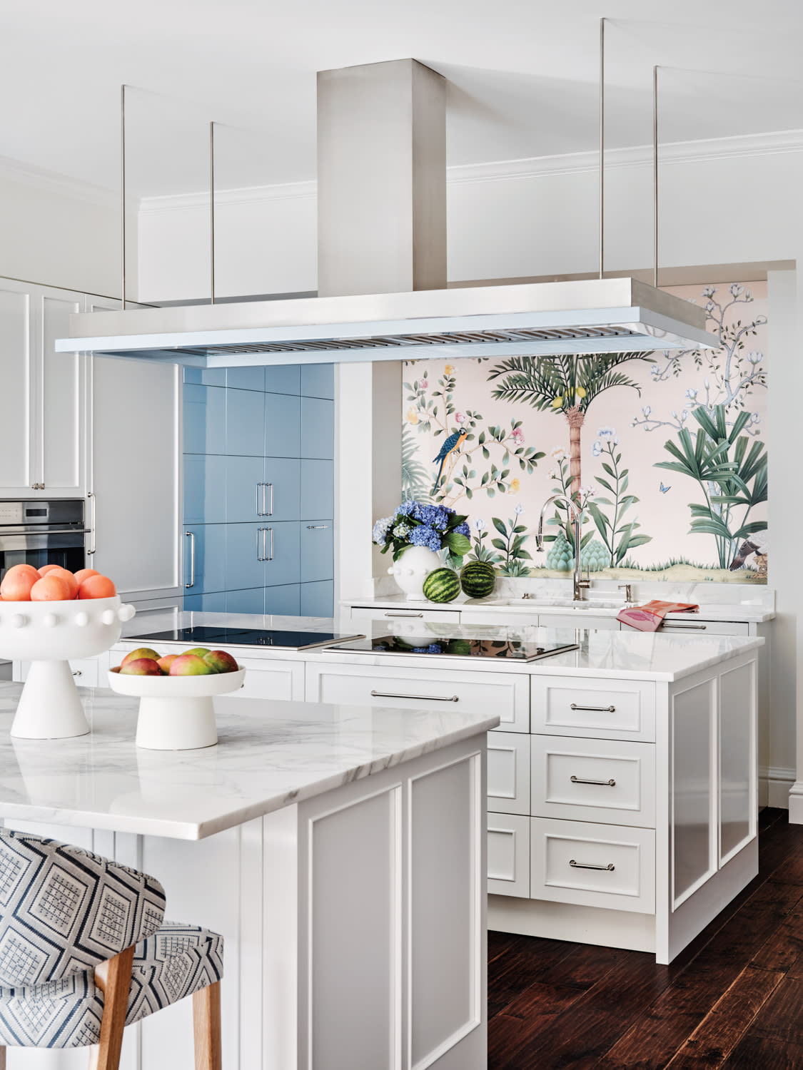 kitchen with two islands, blue cabinetry and a tropical wallcovering backsplash