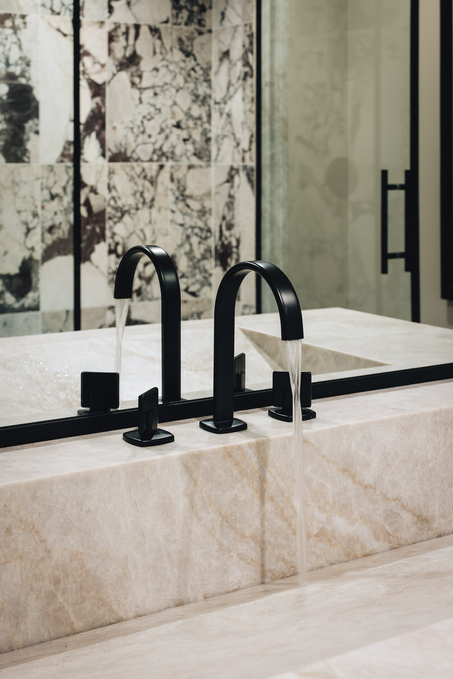 matte black faucet in an off-pink stone sink