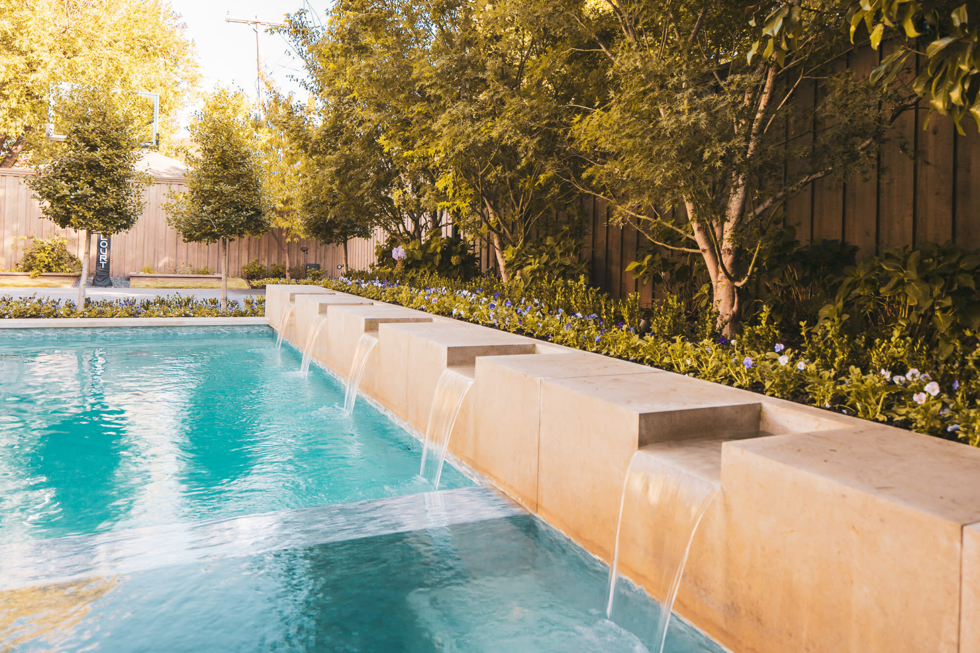 Modern pool with cascading stone water features

