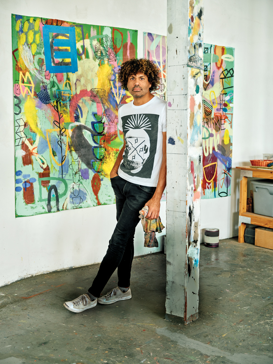 Artist Michael Gadlin standing in his studio in front of one of his abstract paintings.