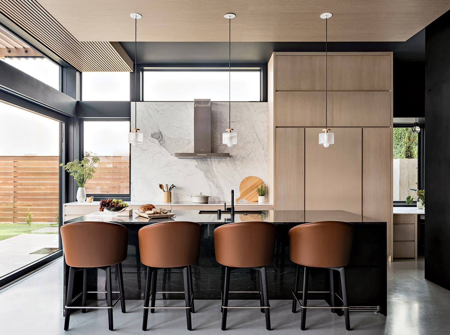 kitchen with white oak cabinetry and barstools lining an island