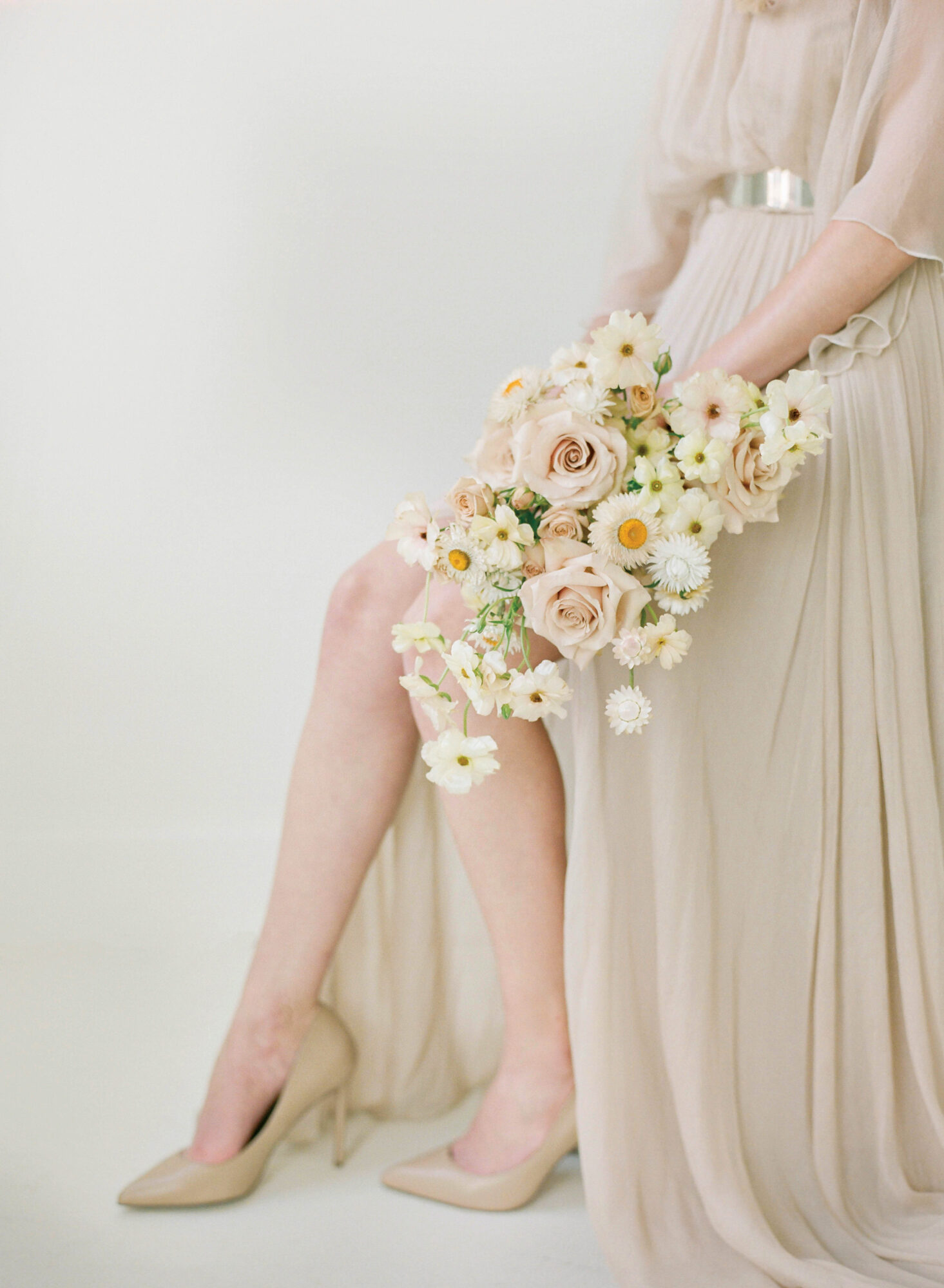 woman in ivory dress holding bouquet of flowers