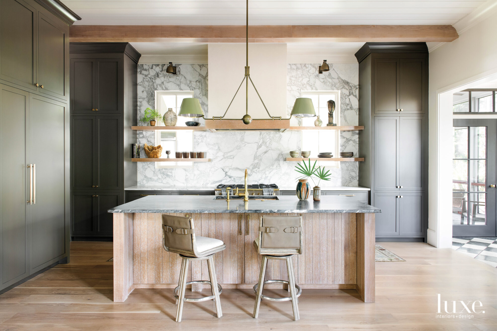 Kitchen with marble backsplash and dark cabinetry towers