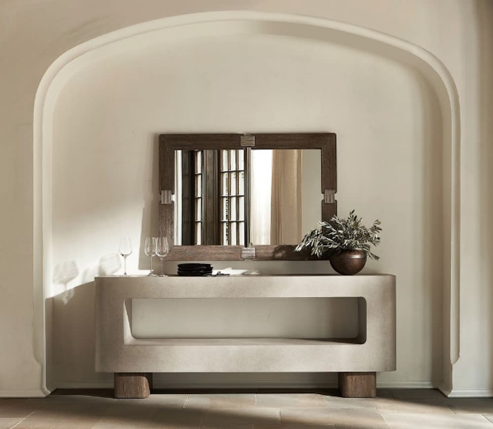 Arched inset in this entry foyer features decorative console table and mirror above.