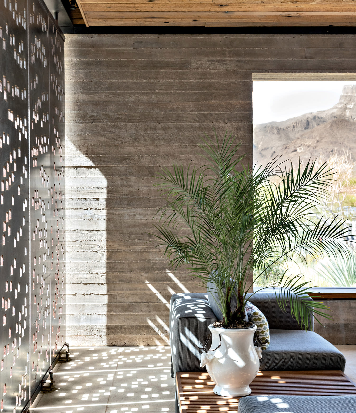a covered porch featuring pivoting steel panels to change the reflection of light throughout the day
