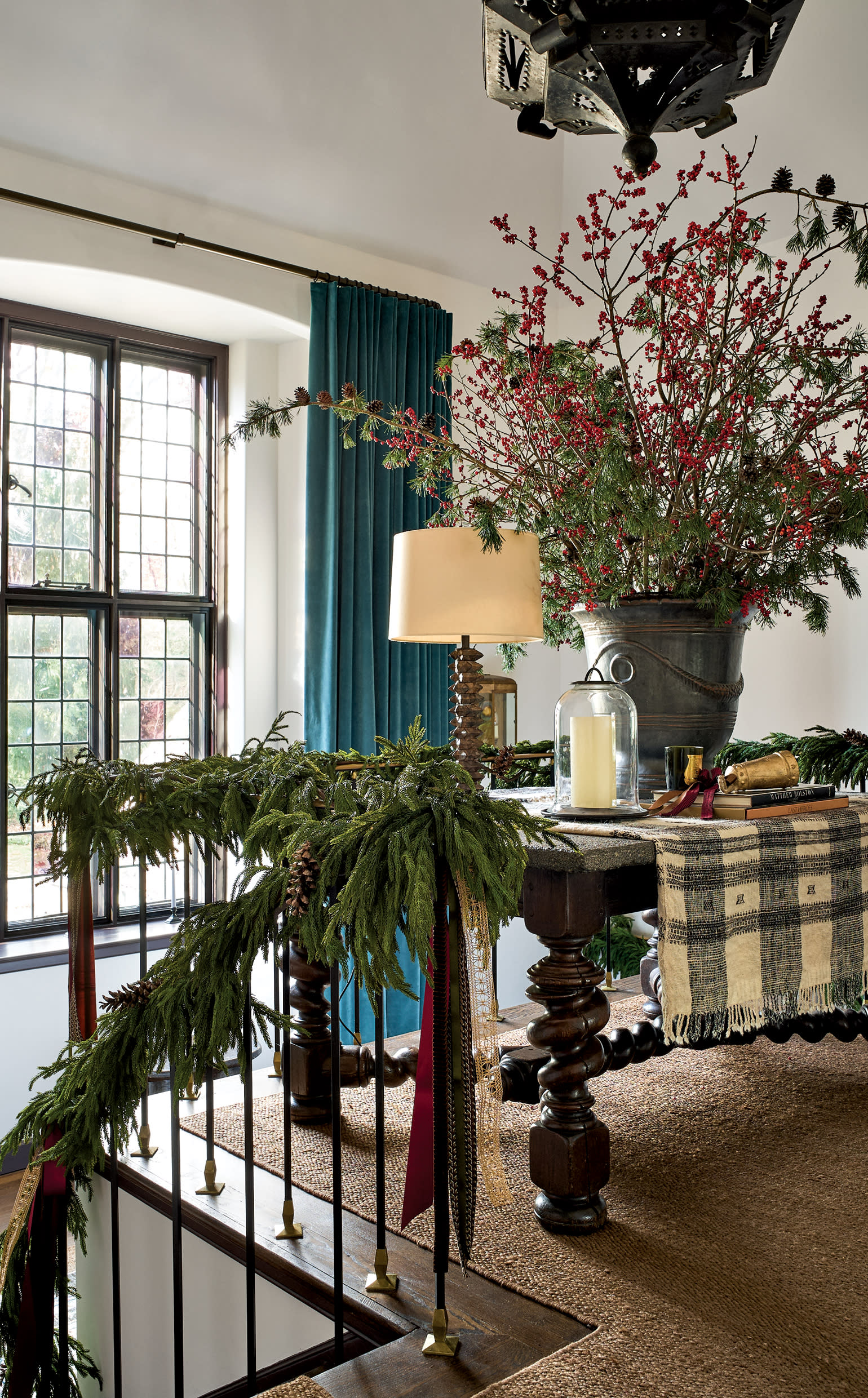 holiday garland draped over iron banister of stairway 