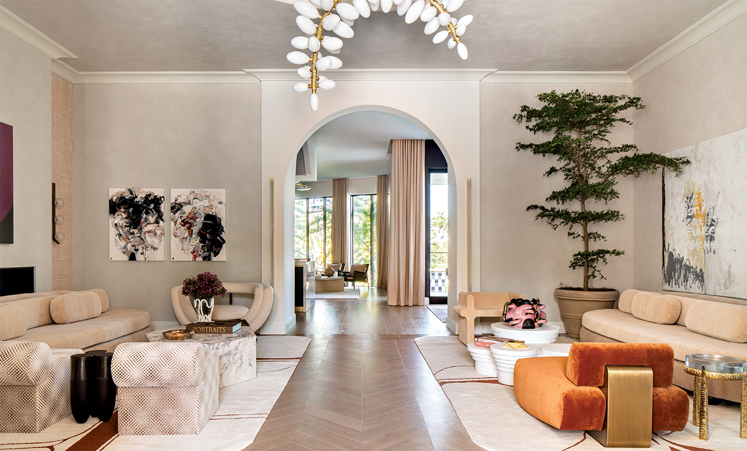 modern living room with a sculptural chandelier and an orange armchair