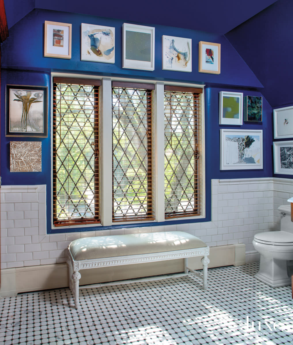 The master bathroom features a blue wall and a collection of framed art.