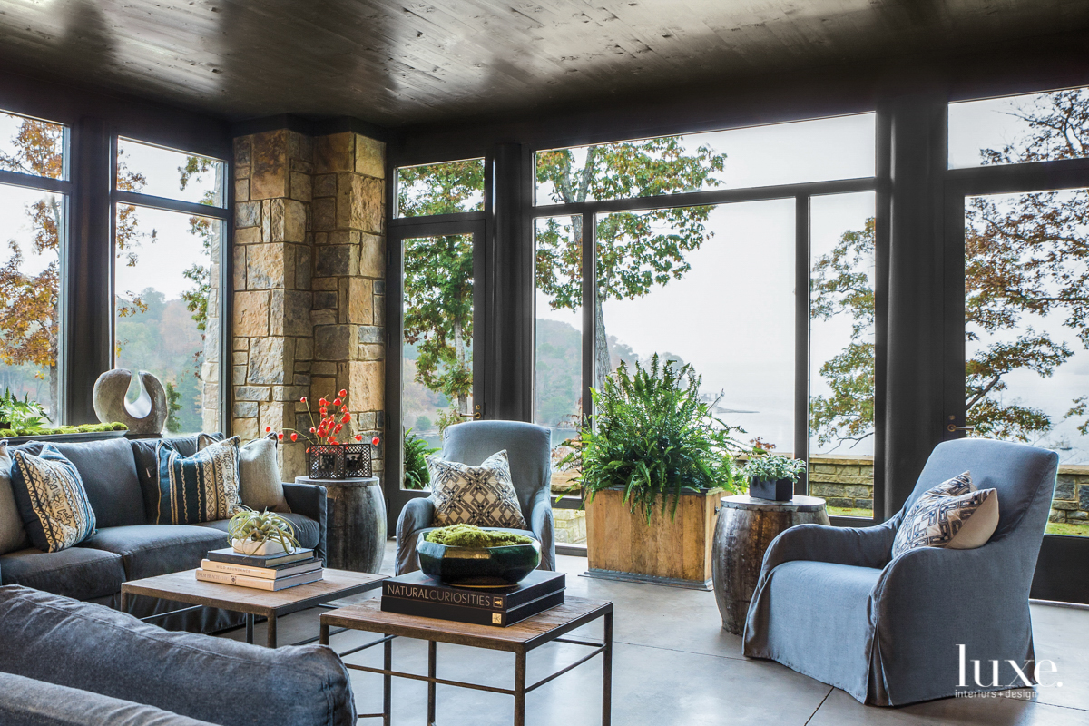 living area with grey chairs and floor to ceiling windows with outside views