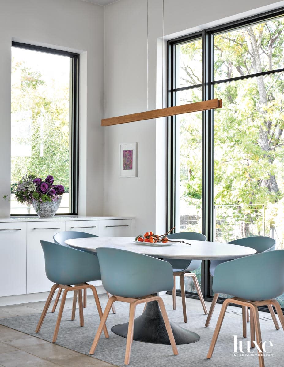 breakfast nook with blue chairs and linear suspension light