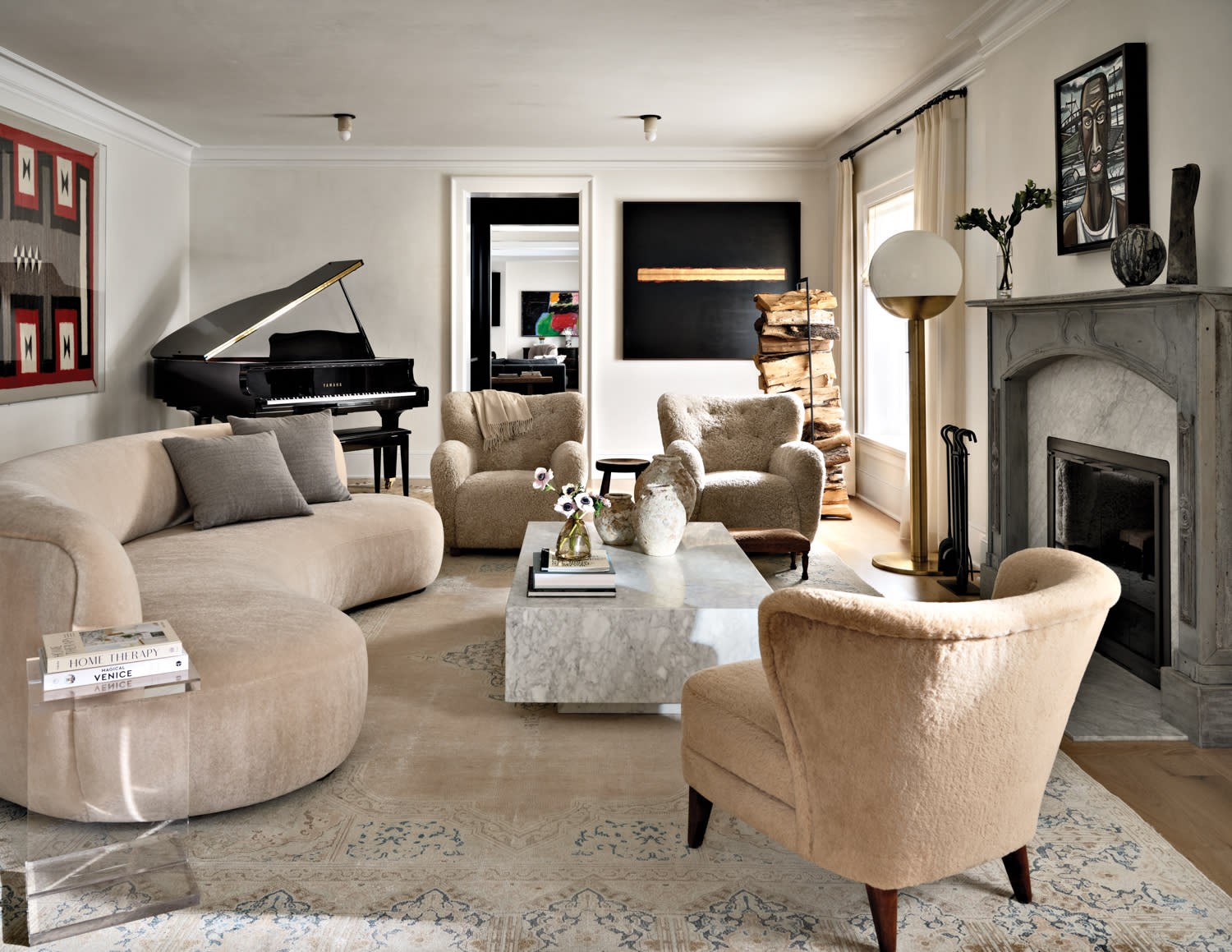 a curvaceous sofa is grouped with three vintage chairs in a classic living room